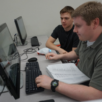 students working on a computer with robot